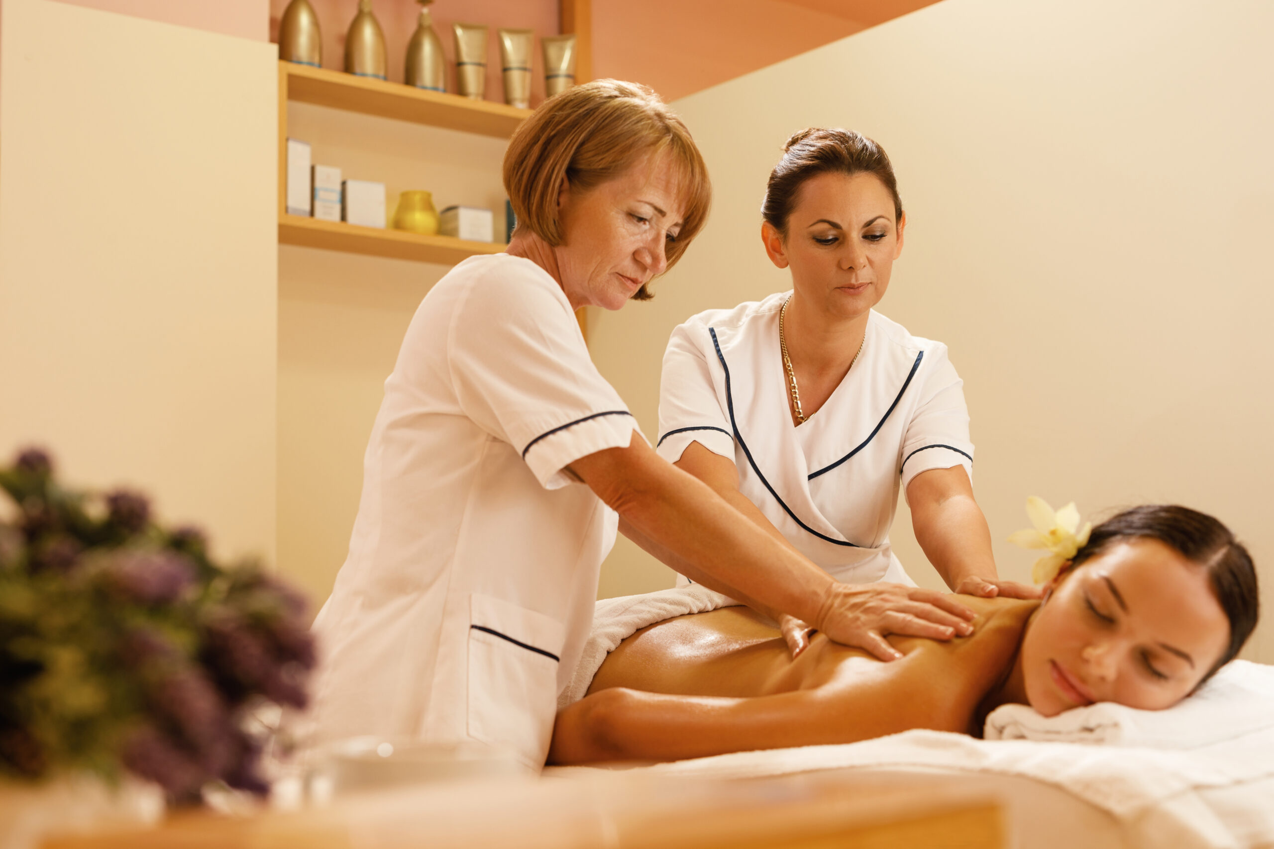 Serene woman getting back massage by two therapists spa treatment scaled