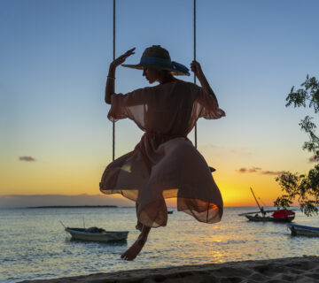 Beautiful girl straw hat pareo swinging swing beach sunset zanzibar island tanzania east africa travel vacation concept 360x320